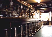Part of a bar interior, furnished with restored 20th Century ship's bar stools and miscellaneous original nautical fixtures, lamps and artefacts.