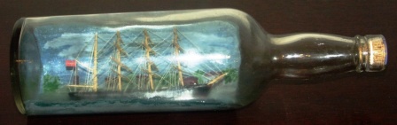 Early 20th century sailor-made ship model housed in bottle depicting a Danish 4-masted barque. 