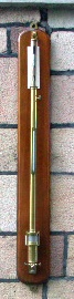 Late 19th century marin mercury barometer with brass case and inset mercury thermometer, mounted on mahogany panel. Made by EDM Wheeler, 18 Jollington Road, Holloway, 319. 