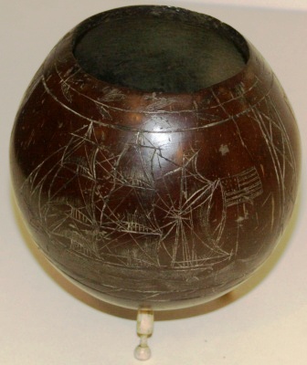 Late 19th century sailor-made carved coconut shell. Decorated with three motifs and mounted on carved whale bone pins.