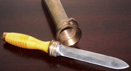 20th century screw-in type diving knife made by Desco. With saw-tooth edge on one side. Brass sheath and wooden handle. 