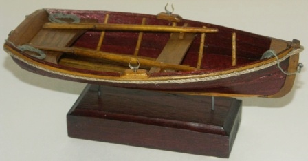 20th century clinker-built wooden dinghy, mounted on wooden base. 