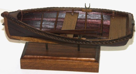 20th century clinker-built wooden dinghy, mounted on wooden base. 