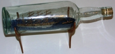 Early 20th century sailor-made ship model housed in bottle depicting a Danish 4-masted barque with towboat. 