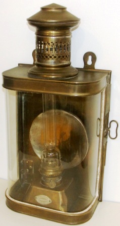 Early 20th century kerosene bulkhead lamp in brass. With detachable burner/container. Made by J. C. Larsén & Co, Österlånggatan 43 Stockholm. 