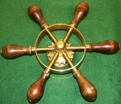 20th century six-spoked brass steering wheel with mahogany handles.