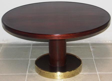 Round coffee table in mahogany. Base mantled with brass.