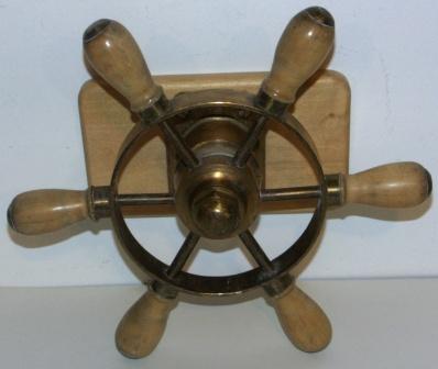 Mid 20th century six-spoked brass steering wheel with oak handles. Mounted on wooden base. 