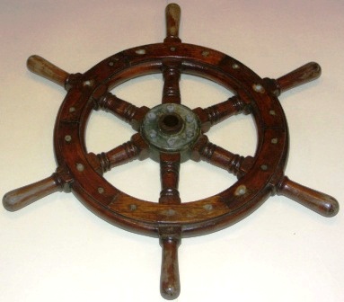 20th century six-spoked laquered oak ships wheel. With brass band and central brass hub.