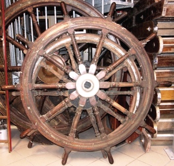 Late 19th century ten-spoked ships wheel. Made of teak. With double brass bands and central brass hub.
