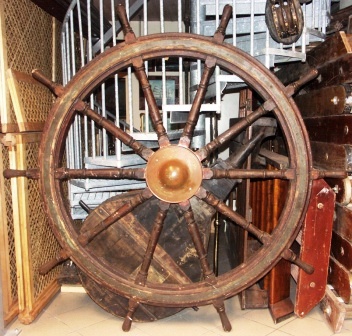 Late 19th century ten-spoked ships wheel. Made of teak. With double brass bands and central iron hub with brass casing.