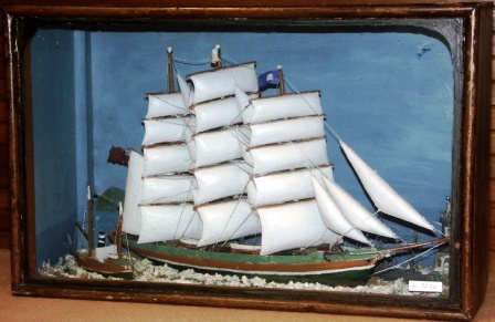 Late 19th century sailor-made diorama. Depicting a fullrigged ship together with a pilot-boat, a naval vessel and a lighthouse. Mounted in origianal case.