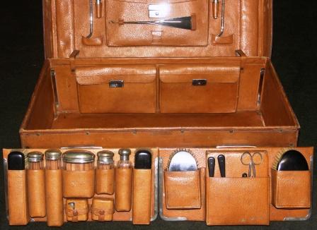 Early 20th century leather suitcase furnished with silver and stainless travelling accessories. Marked with the initials H.H.H. Made by Drew & Sons, Picadilly Circus W.