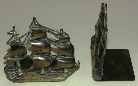 A pair of early 20th century book ends in solid brass depicting HMS Victory. 