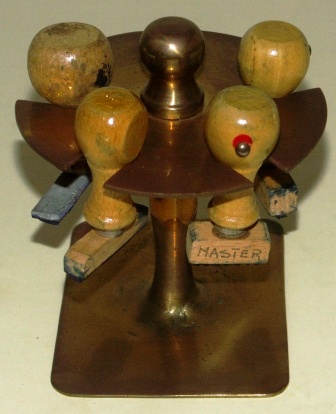 Mid 20th century stamp rack in brass from the Italian liner M/N G. Verdi. Incl 4 stamps marked: M/n VERDI, MASTER, IL I'UFFICIALE and IL COMANDANTE.