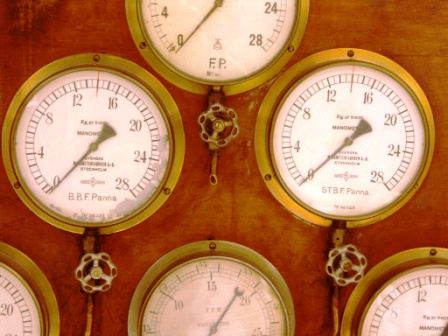 20th century pressure gauges in brass mounted on wooden panel